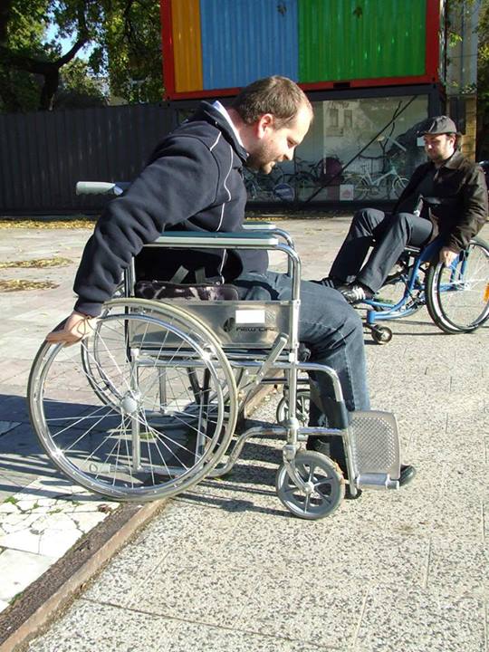 two men trying to ride wheelchairs